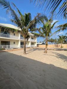 two palm trees in front of a building at Oceanfront Wavecrest Hotel in Lekki