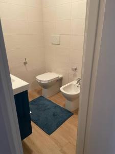 Appartamento Grado Pineta Holidays في غرادو: حمام مع مرحاض وشطاف ومغسلة