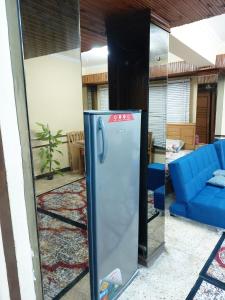 a refrigerator in a living room with a blue couch at شقة فندقية بجوار محطة مترو الدقي in Cairo