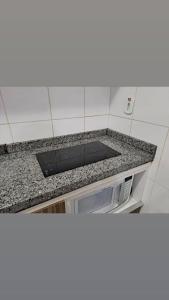 a kitchen counter top with a microwave on it at Lacqua Diroma apartamento barato in Caldas Novas