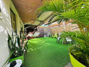 a room with a green floor with plants and chairs at Tartane beach spa in La Trinité