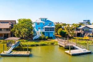 una casa azul en el agua con muelle en The Blue Pelican, en Edisto Beach