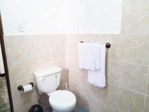 a bathroom with a white toilet and towels at Apartamento Via 7 in Guatemala