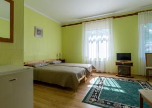 um quarto com uma cama, uma televisão e um tapete em Jūras Brīze em Ventspils