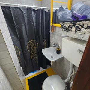 a bathroom with a black shower curtain and a toilet at SEA VIEW ASHDOD in Ashdod