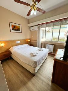 um quarto com uma cama e uma ventoinha de tecto em Hotel GHC em San Clemente del Tuyú