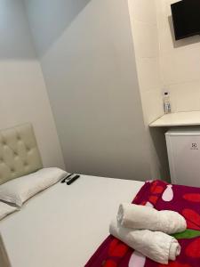 um pequeno quarto com uma cama com toalhas em Terra Encantada Pousada Fernando de Noronha em Fernando de Noronha