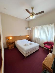 um quarto de hotel com uma cama e uma ventoinha de tecto em Hotel GHC em San Clemente del Tuyú
