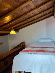 a bedroom with a bed and a wooden ceiling at Casa grande 12 pessoas Rio das onças in Fortim