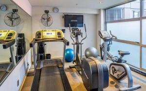 a gym with treadmills and exercise bikes in a room at Naumi Hotel Wellington in Wellington