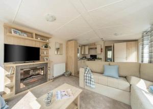 a living room with a couch and a fireplace at Mercury Yacht Harbour And Holiday Park in Lower Swanwick