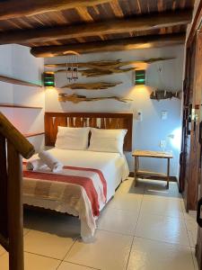 a bedroom with a large bed and a table at Casa grande 12 pessoas Rio das onças in Fortim