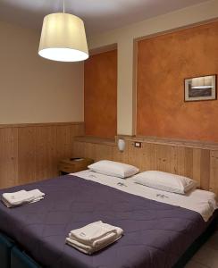 a bedroom with two beds with towels on them at Albergo Baffo in Chiuro