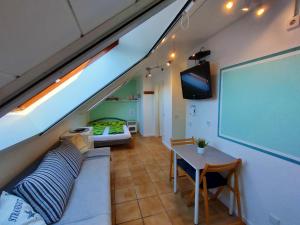 Zimmer mit Sofa, Tisch und Bildschirm in der Unterkunft Auszeit im Grünen - Ferienwohnung in Hünxe in Hünxe