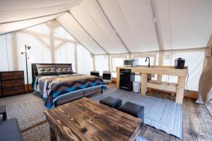 a bedroom with a bed and a table in a tent at Creekside Glamping Current River Mark Twain Forest in Doniphan