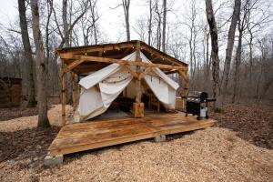 a large wooden dog house in the woods at Creekside Glamping Current River Mark Twain Forest in Doniphan