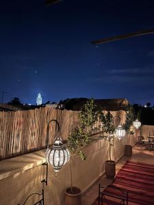 a row of lights on a fence at night at Riad Black Doors in Marrakesh
