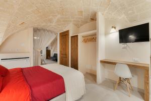 1 dormitorio con 1 cama y TV en la pared en [Exclusive - Suite] SPA con Idromassaggio Jacuzzi, en Fasano