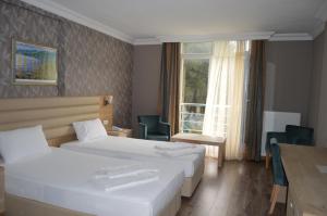 a hotel room with two beds and a window at hotel kale palas in Gokceada Town