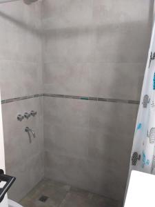 uma casa de banho com chuveiro e cortina de chuveiro em Mono Yoly em Villa Gesell
