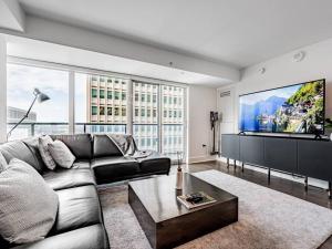 a living room with a couch and a flat screen tv at Luxury Condo on Bay Street in Toronto