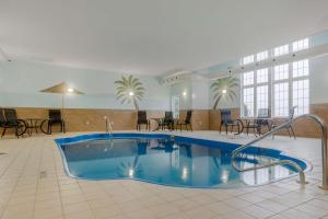 a pool in a hotel lobby with tables and chairs at Best Western Plus Woodstock Hotel Conference Centre in Woodstock