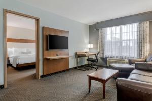 a hotel room with a bed and a living room at Best Western Plus Woodstock Hotel Conference Centre in Woodstock