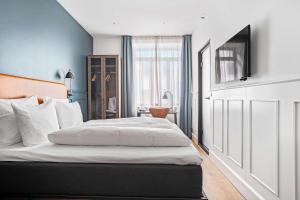 1 dormitorio con 1 cama grande con sábanas blancas en The Huxley Copenhagen, BW Premier Collection, en Copenhague