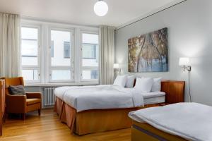 um quarto de hotel com duas camas e uma cadeira em Radisson Blu Aleksanteri Hotel, Helsinki em Helsínquia