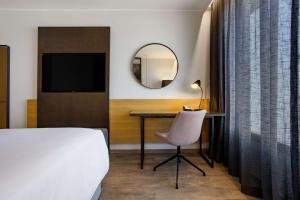 - une chambre avec un lit, un bureau et un miroir dans l'établissement Radisson Blu Hotel Antananarivo Waterfront, à Antananarivo
