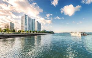 uitzicht op een rivier met hoge gebouwen bij Best Western Premier Sapphire Ha Long in Ha Long