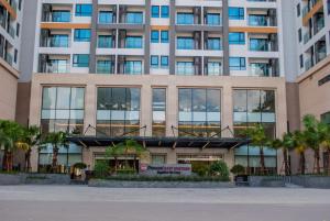 um edifício alto com palmeiras em frente em Best Western Premier Sapphire Ha Long em Ha Long