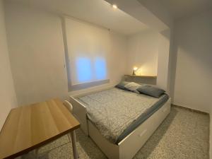 Dormitorio pequeño con cama y mesa en Casa Jesùs, en Ontinyent