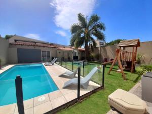 萨尔塔Ref Apart & Hotel的后院设有游泳池和游乐场