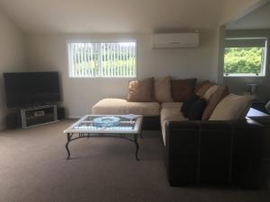 ein Wohnzimmer mit einem Sofa und einem Couchtisch in der Unterkunft Shearer's Quarters in Rotorua