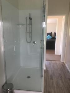 a shower with a glass door in a bathroom at Shearer's Quarters in Rotorua