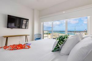 a bedroom with a bed with a view of the ocean at Put On Your Red Shoes And At This Condo in Madiki