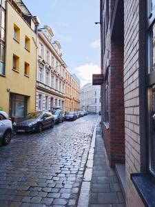 a cobblestone street with parked cars in a city at Apartament dla 1-4 osób w Golden House in Wrocław +14 photos