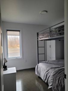 ein Schlafzimmer mit einem Etagenbett und einem Fenster in der Unterkunft Chalet Elizée & Spa in St-Ferdinand