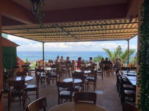 un restaurante con mesas y sillas y vistas al océano en Hotel Villa Salvador, en Salvador