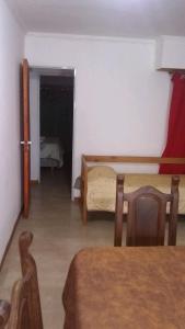 ein Zimmer mit einem Tisch und ein Schlafzimmer mit einem Bett in der Unterkunft Mi Lugar in Olavarría