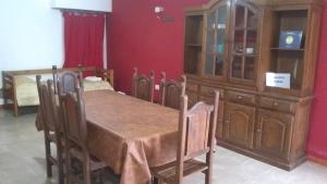 ein Esszimmer mit einem Tisch und einem Holzschrank in der Unterkunft Mi Lugar in Olavarría