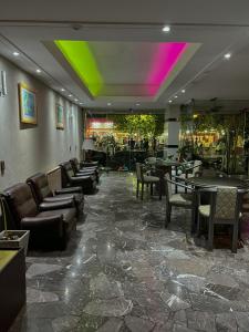 un restaurante con sofás, mesas y un techo colorido en Hotel GHC, en San Clemente del Tuyú