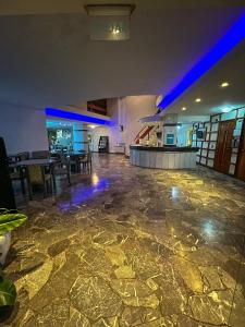 a large room with a stone floor with blue lights at Hotel GHC in San Clemente del Tuyú +81 photos