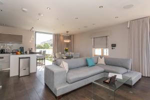 a living room with a couch and a kitchen at Henge House, Penthouse Apartment in Bath