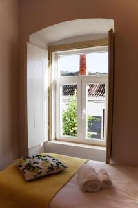 a bed in a room with a window at 4Cantos Alentejo in Mértola