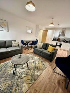 a living room with two couches and a table at Spacious 2 bed ground floor apartment, Free parking, close to Historic dockyard & Gunwharf Quays in Portsmouth