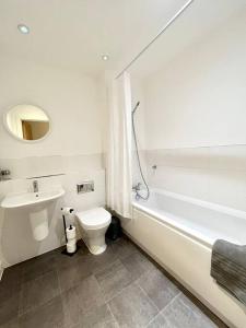 a bathroom with a sink and a toilet and a bath tub at Spacious 2 bed ground floor apartment, Free parking, close to Historic dockyard & Gunwharf Quays in Portsmouth