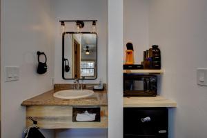 Alpine Lodge Hotel في Cascade: حمام مع حوض ومرآة وميكروويف +37 صورة