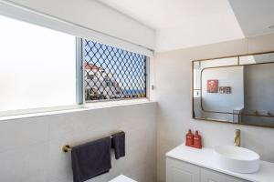 een badkamer met een wastafel en een spiegel bij The Springs - oceanstays in Yamba